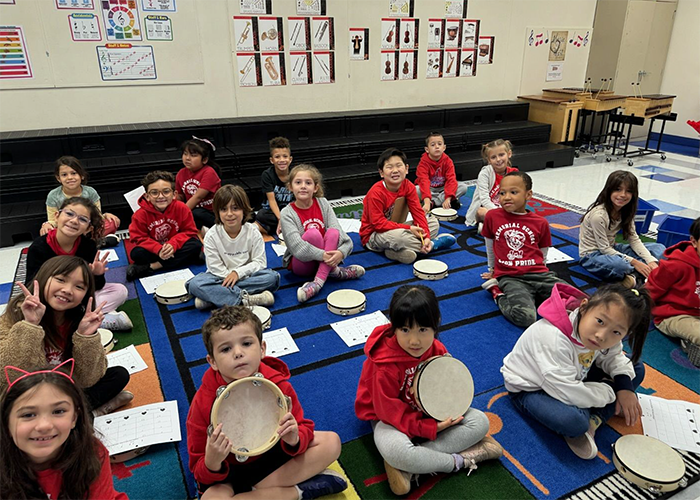 Students sitting in music class holding drums