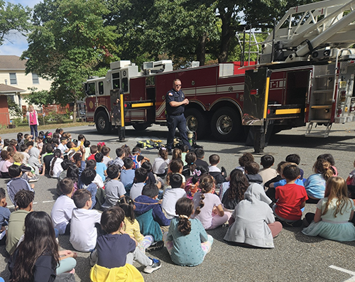 Students sitting down and listening to a firefighter presentation