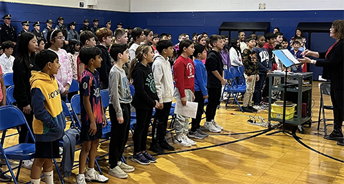 Memorial students singing to honor veterans during ceremony in the school gym