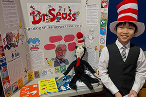 Student in front of their Dr Seuss information presentation board