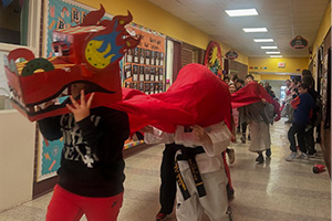 Students walking down the hall with a dragon on their head