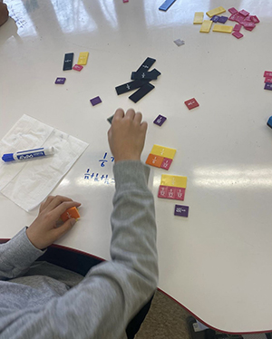 Student working with colorful number blocks at desk